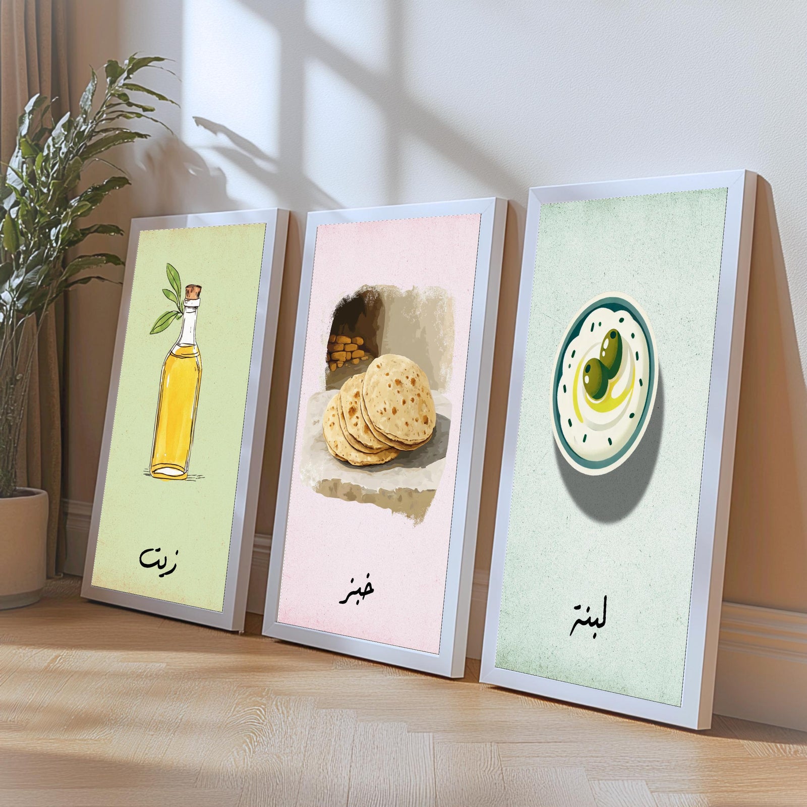 Set of 3 framed canvas triptych featuring illustrated olive oil bottle, flatbread and labneh bowl with Arabic calligraphy labels on soft green, pink and blue pastel backgrounds, displayed above a neutral sofa.