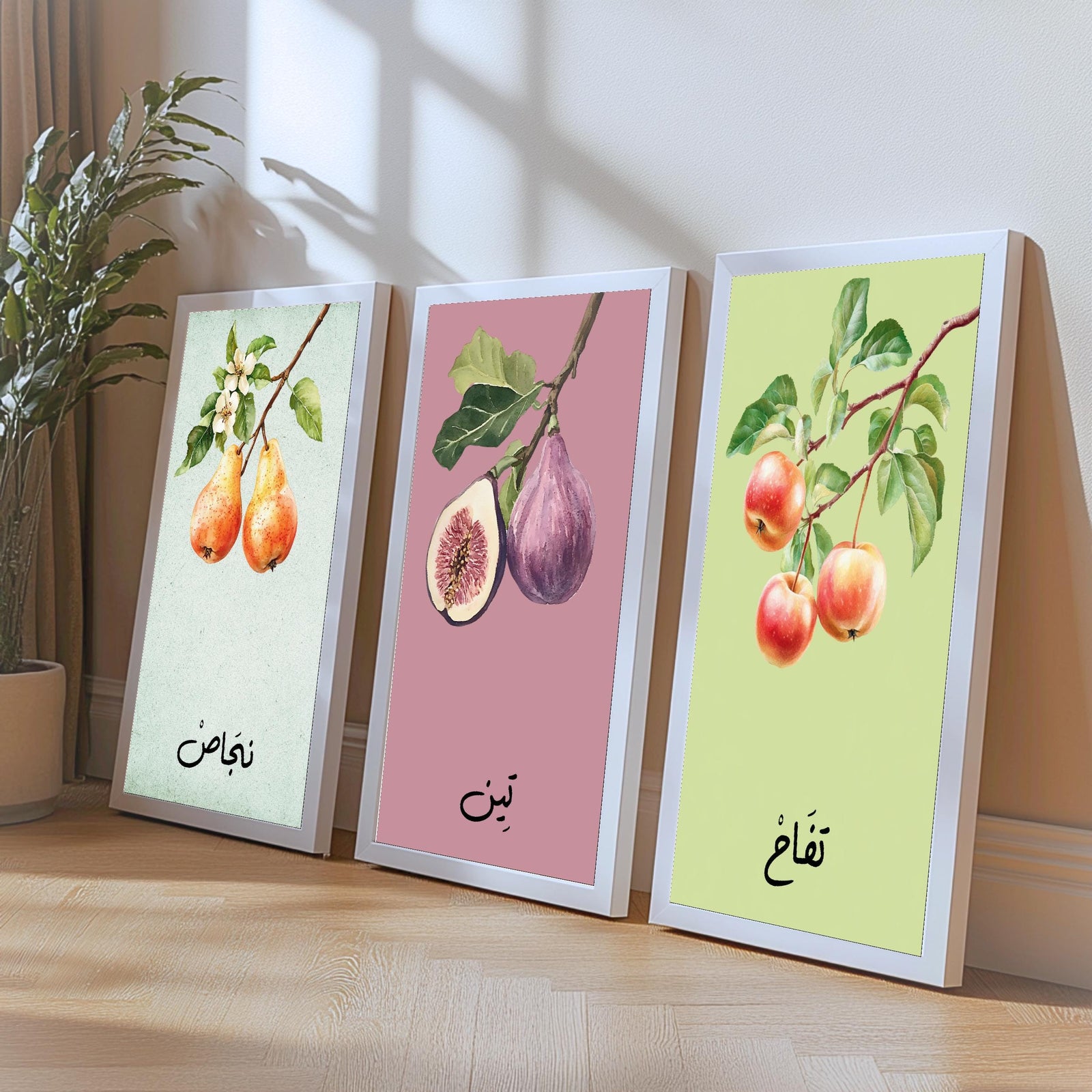 Set of 3 framed canvas triptych featuring soft watercolor botanical illustrations of pear, fig and apple branches with Arabic calligraphy labels on pastel mint, pink and green backgrounds, displayed above a neutral sofa.