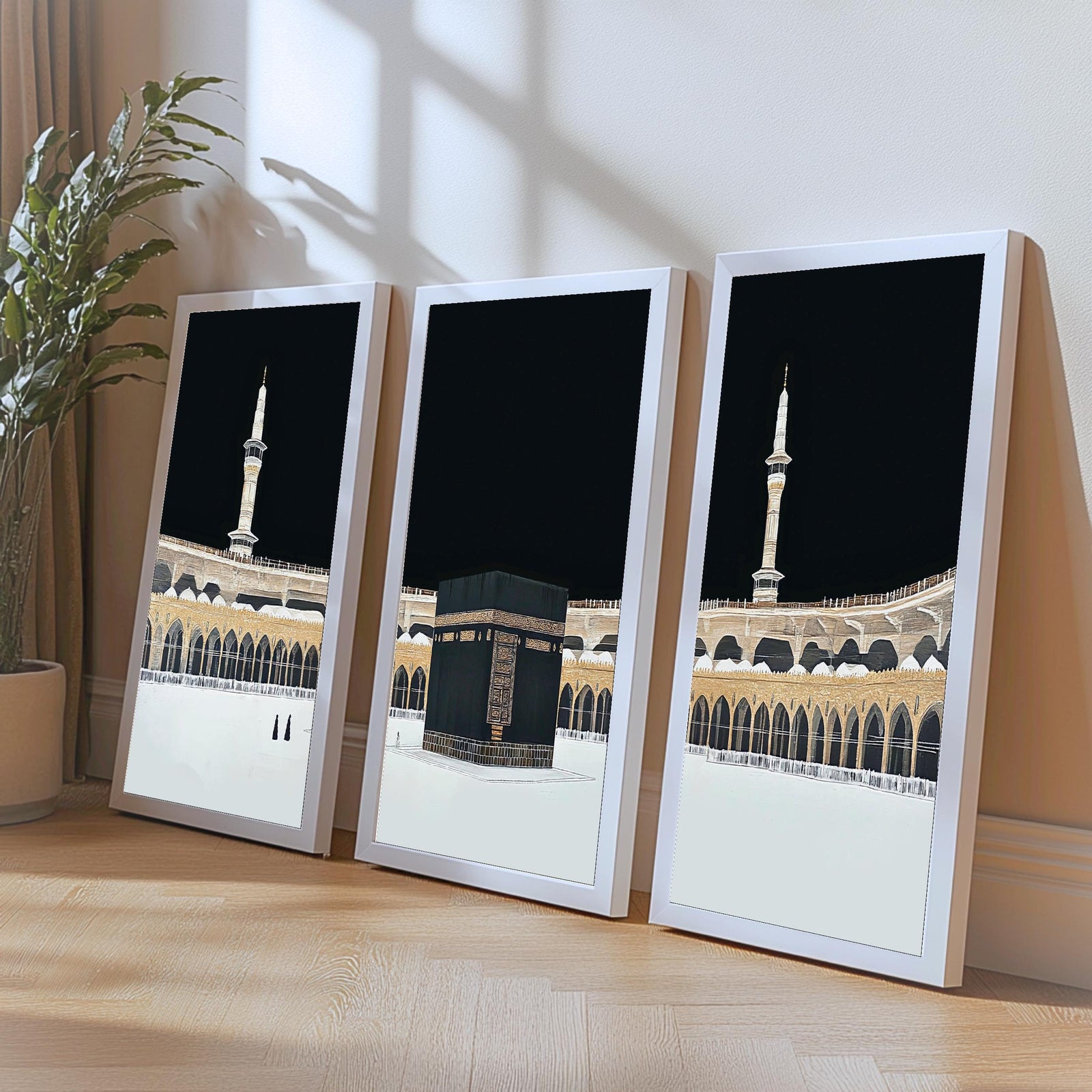 Set of 3 framed canvas triptych showing dramatic night views of Masjid Al-Haram with the Kaaba centered, glowing gold minarets and white marble courtyard against a deep black sky, displayed above a neutral sofa.