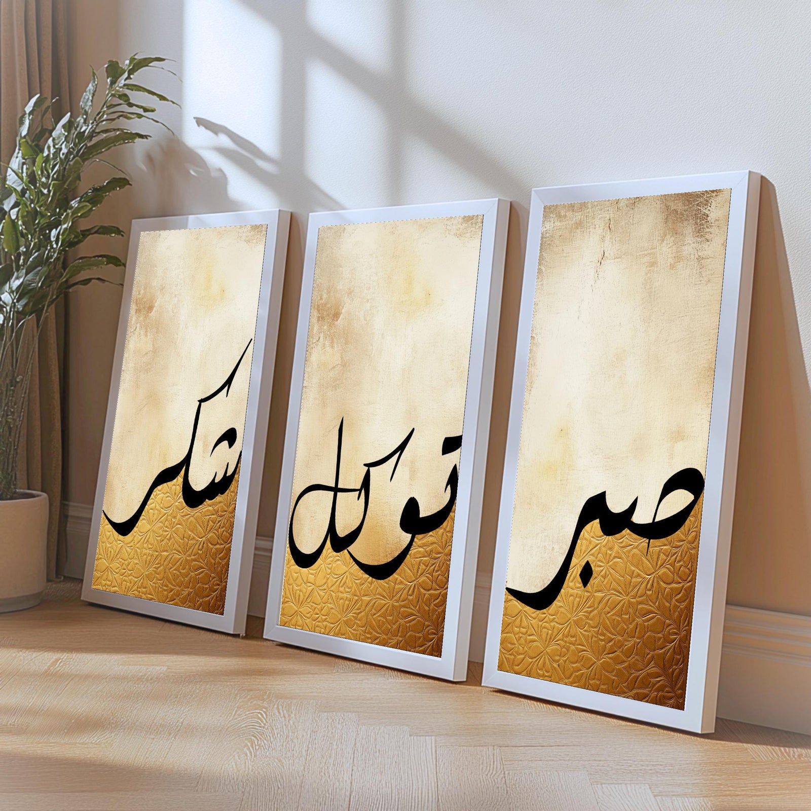 Set of 3 framed canvas triptych featuring Shukr, Tawakkul and Sabr in bold black Arabic calligraphy on a warm amber and cream textured background, displayed above a neutral sofa in a modern living room.