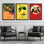 Set of 3 framed canvas triptych featuring bold retro illustrations of orange, lemon and cherry with Arabic calligraphy labels on vibrant orange, yellow and red backgrounds, displayed above a neutral sofa.