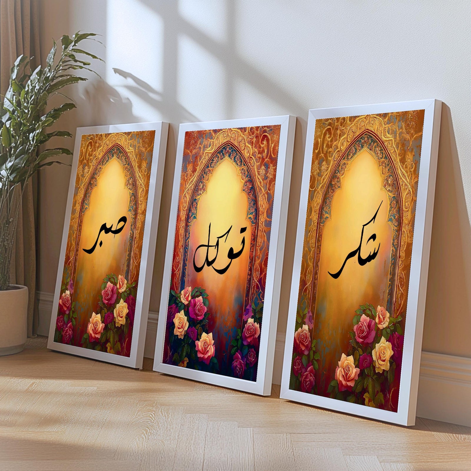 Set of 3 framed canvas triptych with Sabr, Shukr and Tawakkul Arabic calligraphy inside golden Islamic arches, rich red and amber tones with painted roses, displayed on a warm neutral wall above a grey sofa.