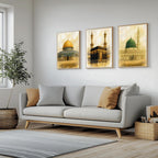 Set of 3 framed canvas triptych depicting the Dome of the Rock, the Kaaba and Al-Masjid An-Nabawi in a soft antique sepia and gold manuscript style, displayed above a neutral sofa in a modern living room.