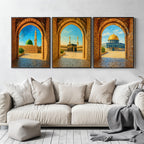 Set of 3 framed canvas triptych showing Al-Masjid An-Nabawi, the Kaaba and the Dome of the Rock viewed through realistic rustic sandstone arches with cobblestone courtyards under a bright blue sky, displayed above a neutral sofa.