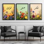 Set of 3 framed canvas triptych with Tawakkul, Sabr and Shukr in Arabic calligraphy above vibrant wildflower gardens on pastel yellow, green and peach backgrounds, displayed above a neutral sofa.