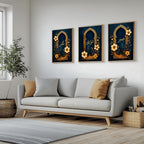 Set of 3 framed canvas triptych with Sabr, Shukr and Tawakkul in gold Arabic calligraphy inside ornate navy and gold Islamic arches surrounded by yellow and dark blue flowers, displayed above a grey sofa.