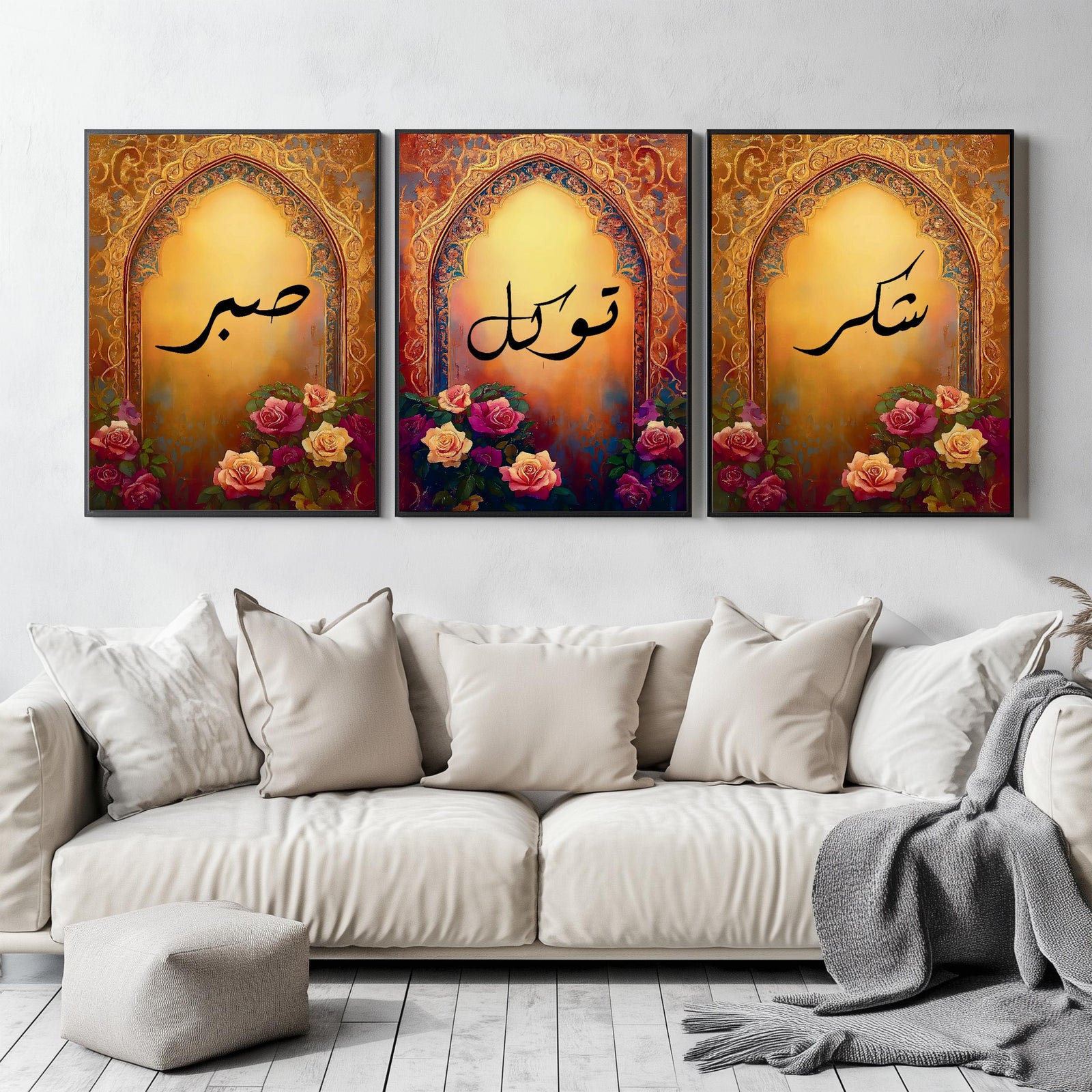 Set of 3 framed canvas triptych with Sabr, Shukr and Tawakkul Arabic calligraphy inside golden Islamic arches, rich red and amber tones with painted roses, displayed on a warm neutral wall above a grey sofa.