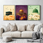Set of 3 framed canvas triptych showing the Kaaba, Dome of the Rock and Al-Masjid An-Nabawi with oversized peony flowers and birds in flight, each panel on a distinct yellow, purple and green background.