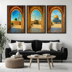 Set of 3 framed canvas triptych showing Al-Masjid An-Nabawi, the Kaaba and the Dome of the Rock viewed through realistic rustic sandstone arches with cobblestone courtyards under a bright blue sky, displayed above a neutral sofa.