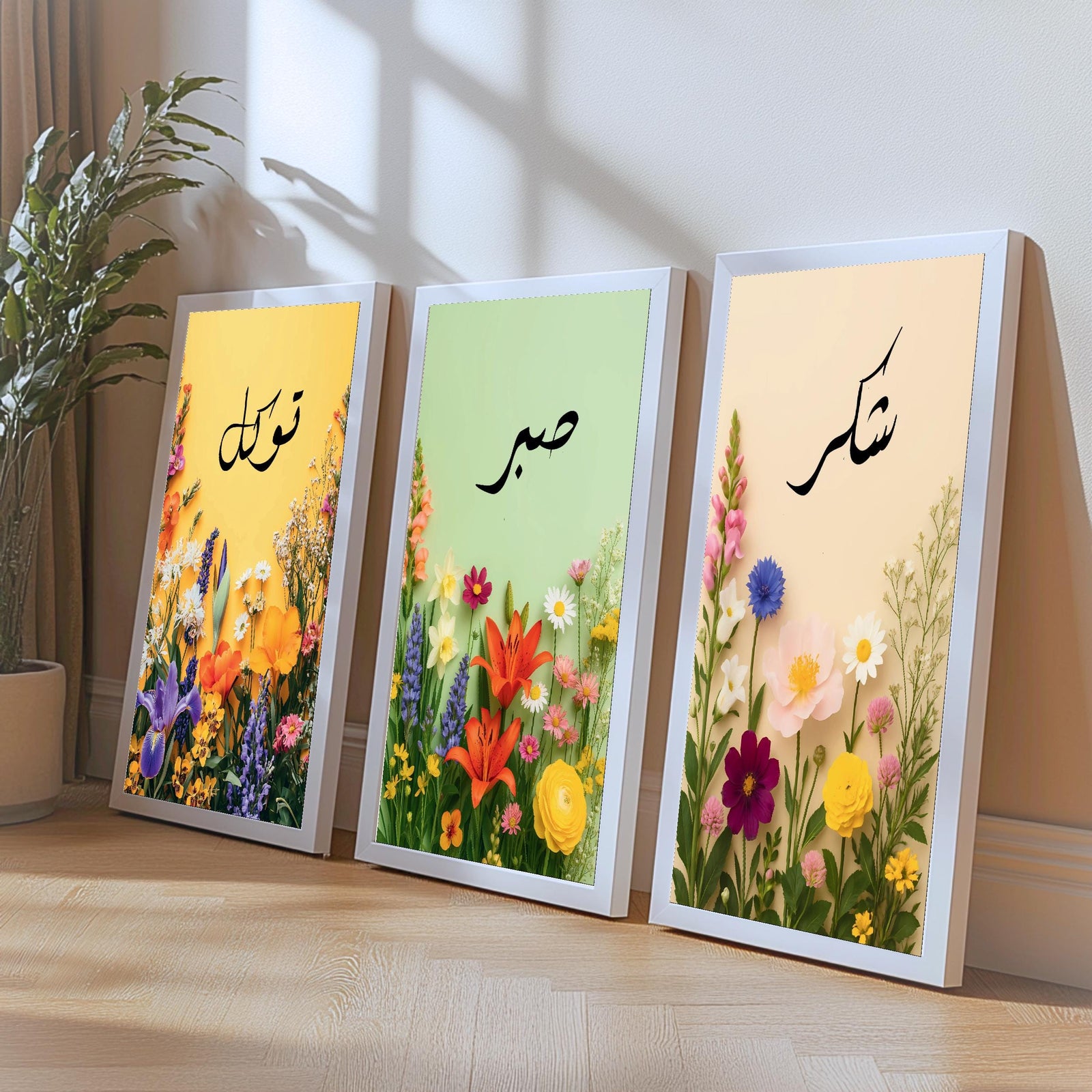 Set of 3 framed canvas triptych with Tawakkul, Sabr and Shukr in Arabic calligraphy above vibrant wildflower gardens on pastel yellow, green and peach backgrounds, displayed above a neutral sofa.