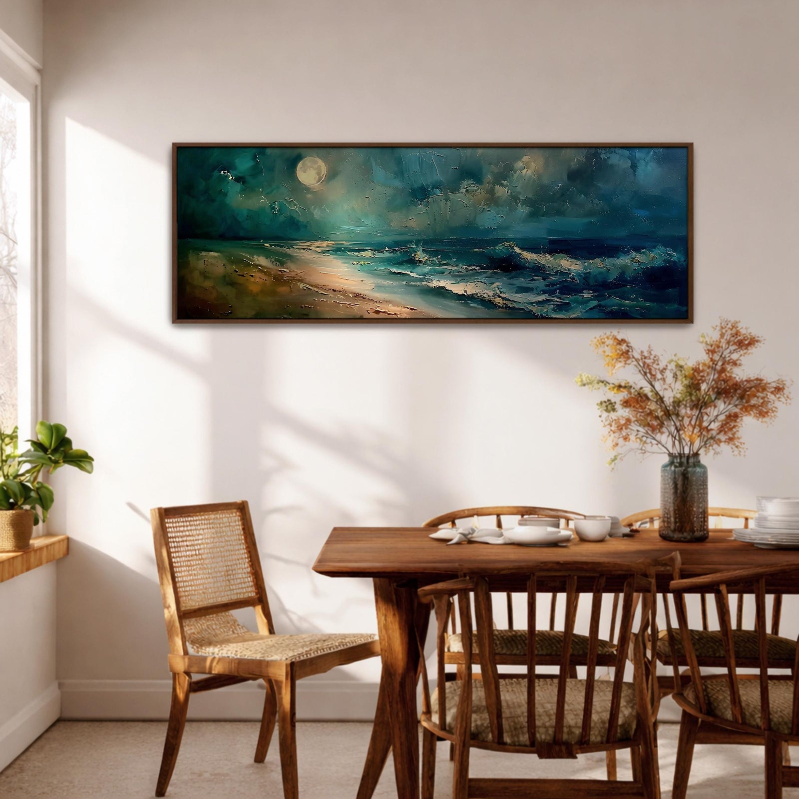 Panoramic seascape painting of ocean waves rolling onto a sandy shoreline beneath a glowing full moon. Deep teal and blue tones fill the night sky while moonlight reflects across the water and highlights textured waves and foam along the beach, creating a dramatic coastal scene in a wide horizontal composition.