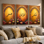 Set of 3 framed canvas triptych with Sabr, Shukr and Tawakkul Arabic calligraphy inside golden Islamic arches, rich red and amber tones with painted roses, displayed on a warm neutral wall above a grey sofa.