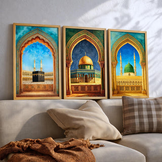 Set of 3 framed canvas triptych showing the Kaaba, Dome of the Rock and Al-Masjid An-Nabawi framed through ornate Islamic arches in rich watercolor teal, blue and gold tones, displayed above a neutral sofa.