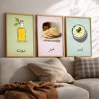 Set of 3 framed canvas triptych featuring illustrated olive oil bottle, flatbread and labneh bowl with Arabic calligraphy labels on soft green, pink and blue pastel backgrounds, displayed above a neutral sofa.