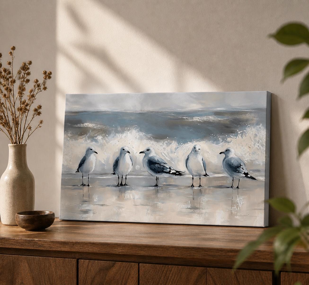A vintage-style framed canvas painting depicting five seagulls standing on a beach shore with ocean waves crashing behind them. The artwork captures the coastal wildlife scene with textured brushstrokes and muted tones, emphasizing the natural habitat and behavior of the shorebirds along the water's edge.