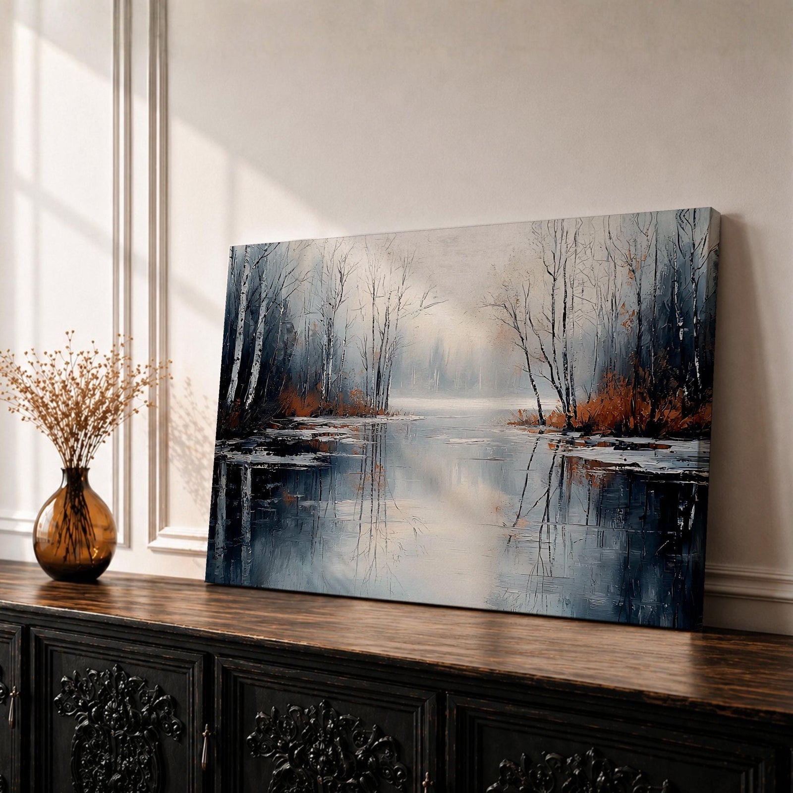 A framed canvas painting depicting a serene winter lake landscape with bare trees reflected in still water. The scene features a quiet woodland setting with leafless trees and subtle earthy tones, capturing the calm and reflective nature of a winter forest by the lake.