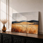 A vintage-style framed canvas painting depicting a vast landscape of golden fields and rolling hills under a muted sky. The textured brushstrokes emphasize the natural prairie scene with tall grasses in the foreground and distant hills, capturing a serene rural environment.