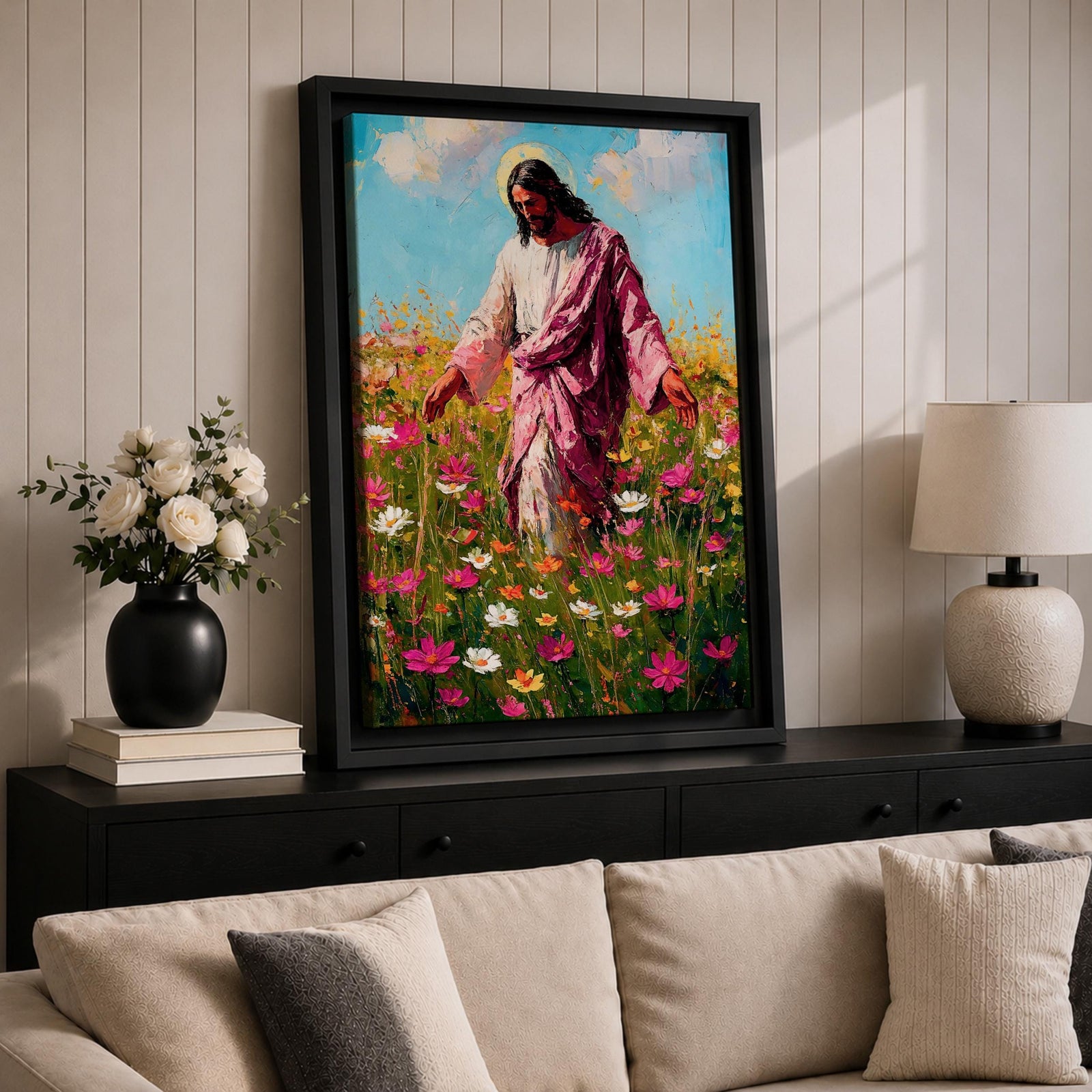 Painting of Jesus Christ walking through a field of blooming wildflowers with arms gently extended while wearing flowing robes and a soft halo behind his head. The scene shows Christ moving among colorful blossoms beneath a bright sky, rendered with expressive painterly brushstrokes that emphasize a peaceful pastoral setting.