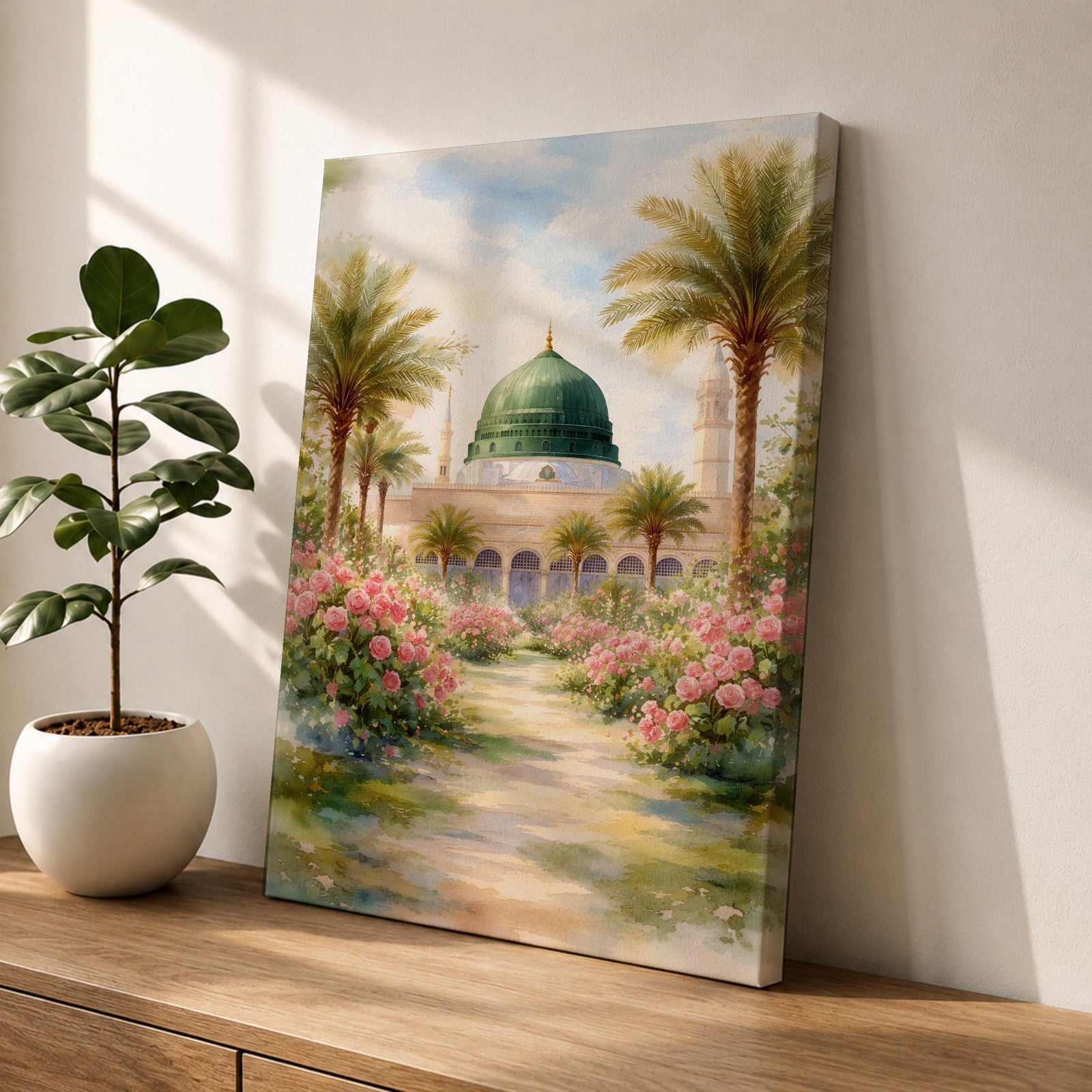 Framed canvas wall art of the Prophet’s Mosque in Medina featuring the iconic green dome, surrounded by palm trees and blooming pink flowers along a sunlit garden path, creating a peaceful and serene Islamic landscape scene for home decor.