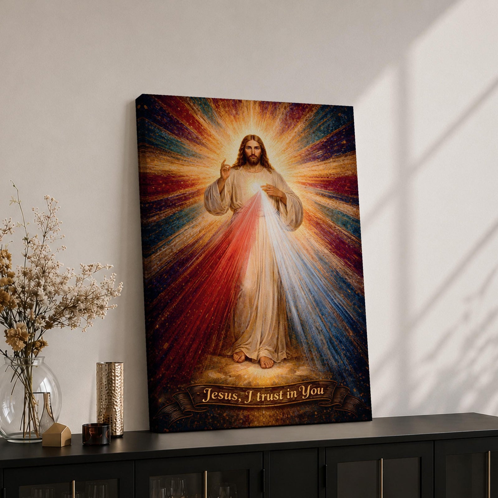 A radiant depiction of Divine Mercy of Jesus shows Jesus standing with one hand raised in blessing and the other pointing to his heart, from which red and pale rays emanate. The figure is surrounded by vibrant rays of light, rendered in a classical religious art style on canvas.