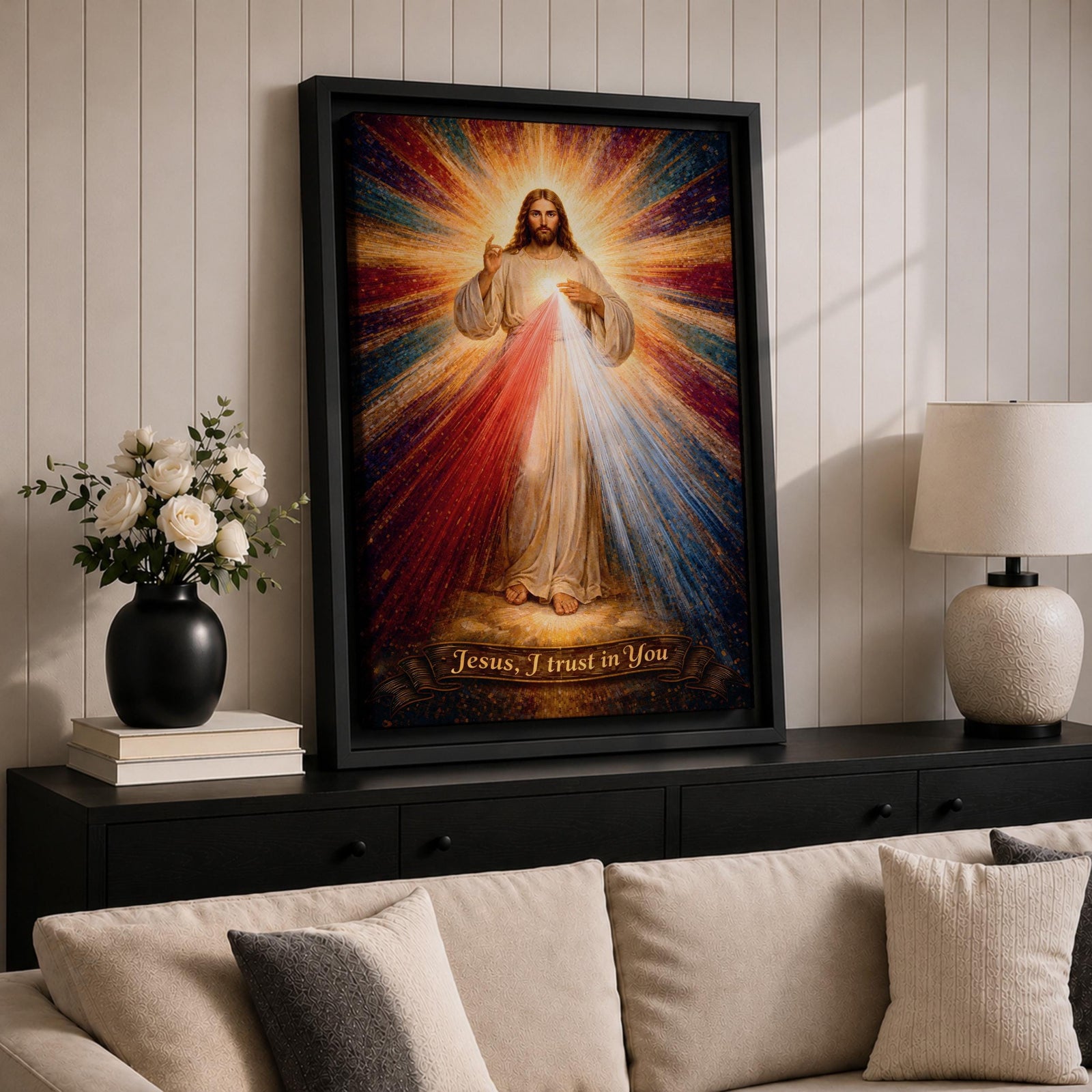 A radiant depiction of Divine Mercy of Jesus shows Jesus standing with one hand raised in blessing and the other pointing to his heart, from which red and pale rays emanate. The figure is surrounded by vibrant rays of light, rendered in a classical religious art style on canvas.