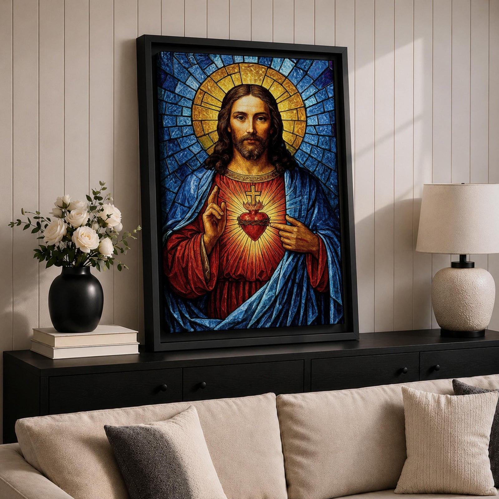 A stained glass style depiction of the Sacred Heart of Jesus shows Jesus with long hair and beard, wearing a red robe and blue cloak. His heart is radiant with light, crowned with a cross and surrounded by thorns. The background features geometric blue and gold stained glass tiles forming a halo.