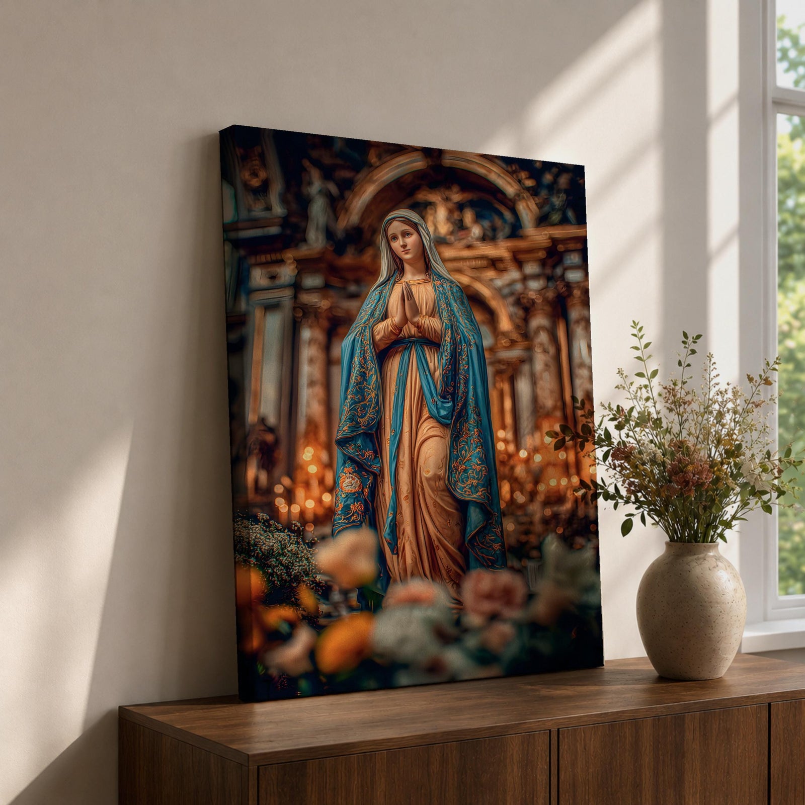 A detailed framed canvas print depicting Our Lady of Lourdes, showing the Virgin Mary in a traditional pose with hands clasped in prayer, wearing a flowing robe and veil, set against a softly blurred background of candles and floral elements, emphasizing religious devotion and reverence.