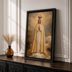 A detailed framed canvas painting of Our Lady of Fatima, depicting the Virgin Mary crowned and standing on clouds with hands in prayer, wearing a white and gold robe, rendered in a classic religious style with textured brushstrokes and a glowing background.