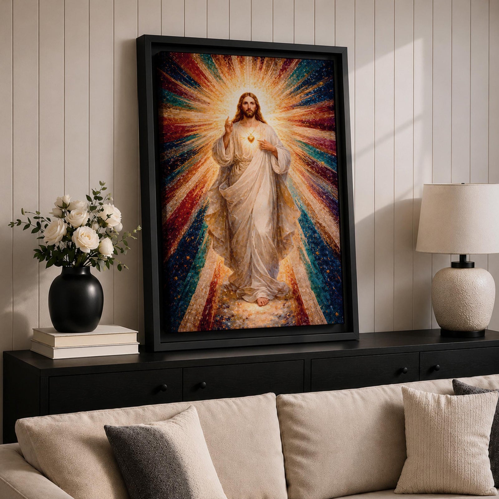 A mosaic-style framed canvas depicting the Sacred Heart of Jesus with radiant beams of light emanating from the heart. The figure is dressed in flowing robes with one hand raised in blessing and the other pointing to the glowing heart, set against a vibrant, colorful mosaic background.