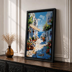 An impasto style painting depicting a charming Greek island village street with whitewashed buildings, colorful flowers in pots, balconies, and a view of the blue sea under a partly cloudy sky. The textured brushstrokes create a vivid Mediterranean coastal atmosphere.