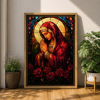 A stained glass style artwork depicting the Virgin Mary in a red robe with hands clasped in prayer, surrounded by a glowing halo and red roses at the bottom. The piece features intricate glass-like segments and rich colors, capturing a classic religious stained glass window aesthetic.