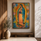 A vibrant framed canvas depicting Our Lady of Guadalupe, showing the Virgin Mary with hands clasped in prayer, wearing a blue mantle adorned with stars and a pink dress, surrounded by radiant golden rays and a colorful abstract background.