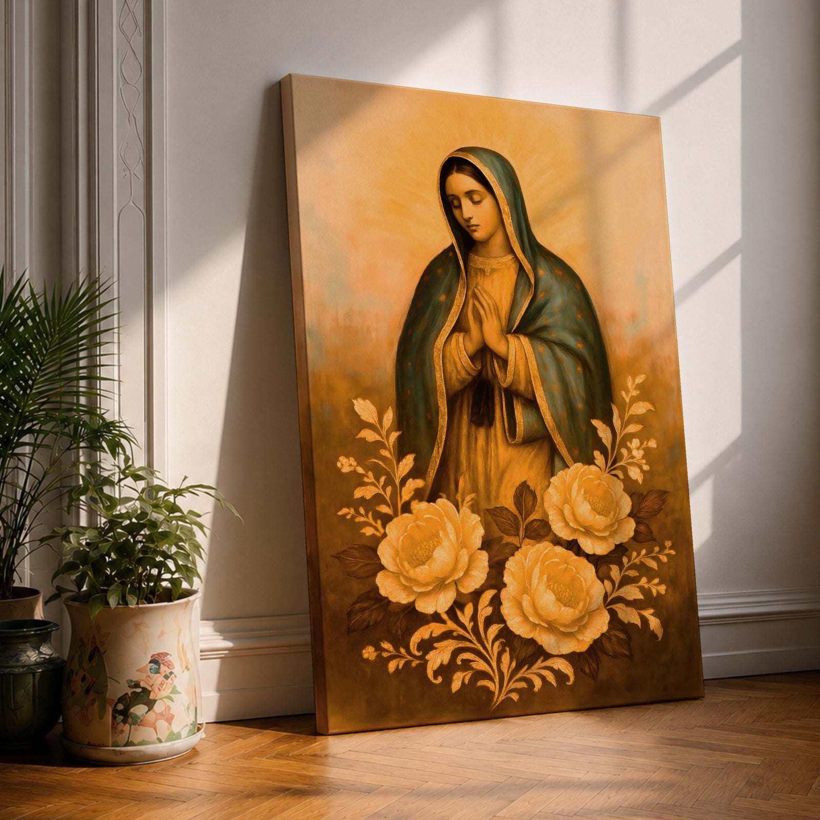 A vintage-style framed canvas depicting Our Lady of Guadalupe with her hands folded in prayer, wearing a blue mantle with gold trim, surrounded by large floral motifs. The artwork captures the traditional Catholic iconography with soft, warm tones and detailed floral decoration below the figure.