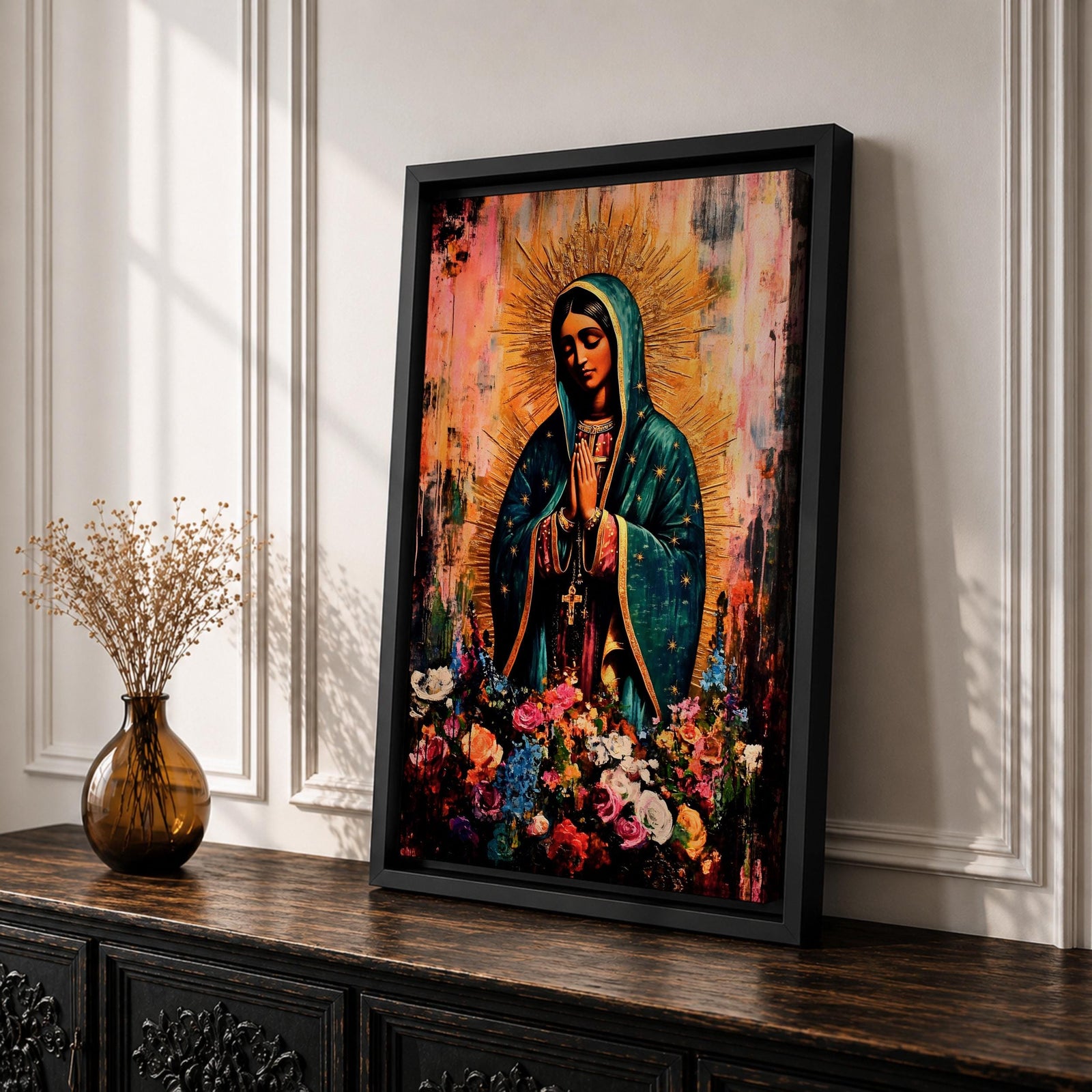 A devotional depiction of La Virgen Morena as Our Lady of Guadalupe standing with hands clasped in prayer, wearing a rose colored gown and a teal mantle covered in gold stars, surrounded by radiant golden rays and standing above a crescent moon with an angel beneath, framed by floral elements in a Mexican Catholic style.