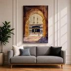 Watercolor-style artwork of the Kaaba at Masjid Al Haram in Mecca viewed through a grand mosque archway with open golden doors and pilgrims gathered in the courtyard beneath tall minarets.