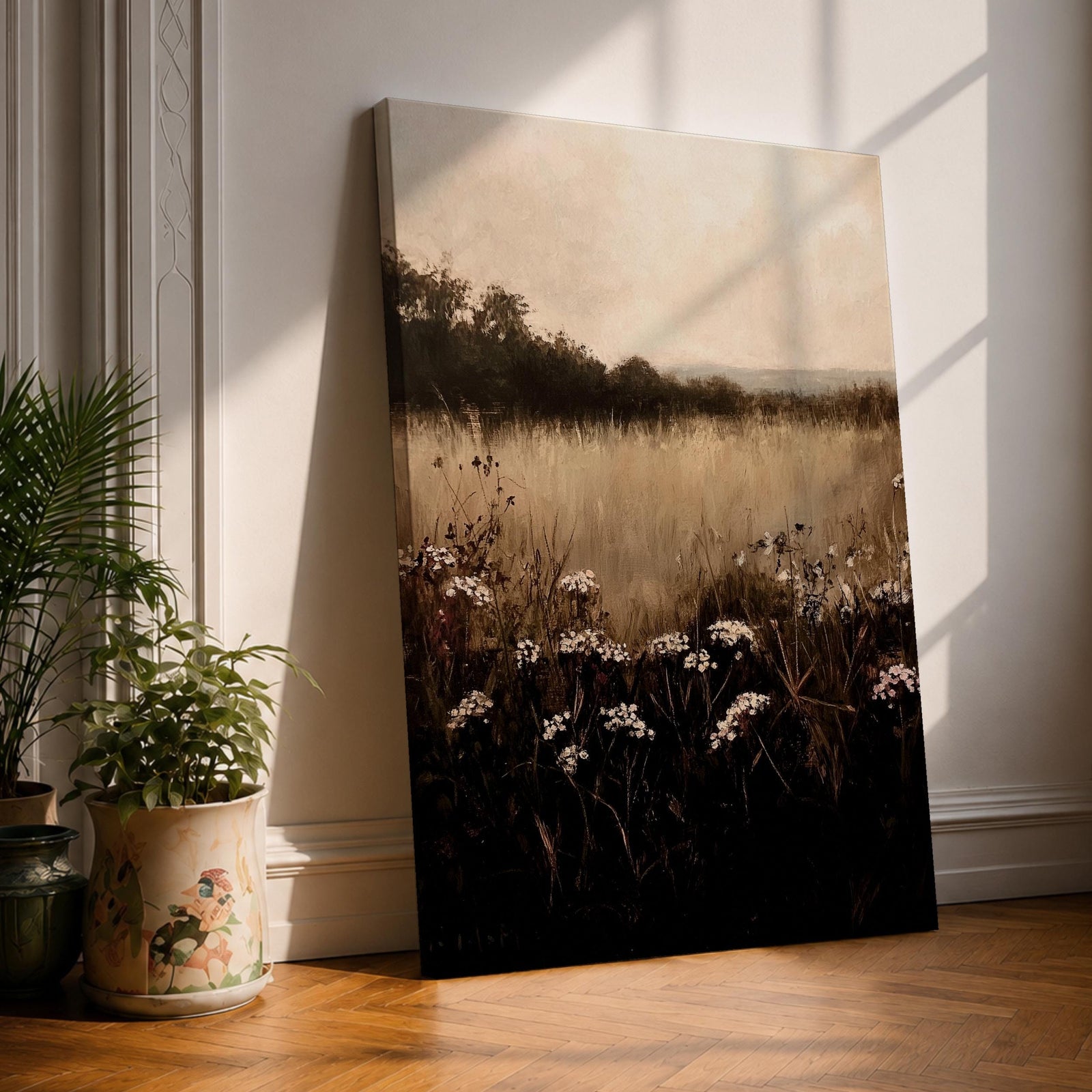 A framed canvas painting depicting a wildflower landscape with tall grasses and clusters of white wildflowers in the foreground, fading into a soft, hazy meadow and distant tree line under a muted sky, rendered in a naturalistic style emphasizing texture and depth.