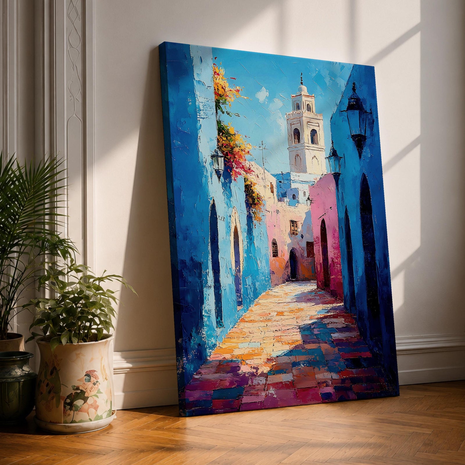 Colorful Moroccan medina alley wall art featuring vibrant blue walls, traditional Islamic architecture, and a narrow street leading toward a historic tower. Moorish cityscape inspired by Chefchaouen style, framed canvas decor for boho, Moroccan, and Islamic interior design.