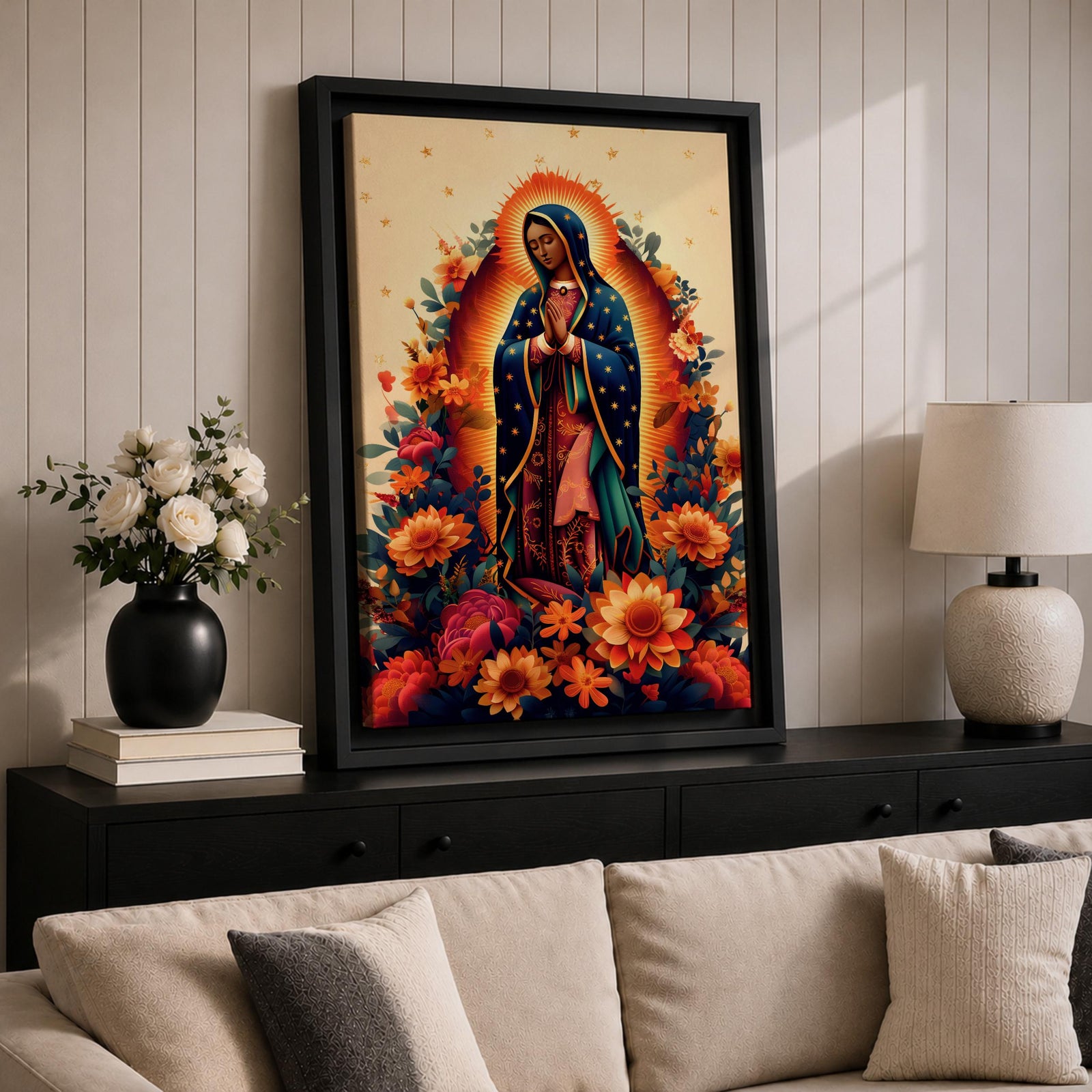 A devotional depiction of La Guadalupana as Our Lady of Guadalupe standing with hands clasped in prayer, wearing a rose pink gown and a teal mantle covered with gold stars, surrounded by radiant golden rays and standing above a crescent moon with an angel beneath, framed with floral elements in traditional Mexican Catholic style.