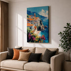 This impasto style framed canvas depicts the Amalfi Coast featuring a cluster of Italian villas with terracotta roofs perched on cliffs overlooking a vibrant blue Mediterranean sea under a partly cloudy sky, with colorful flowers in the foreground enhancing the coastal landscape scene.