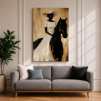 A framed painting of a woman dressed in a white dress and wide-brimmed hat riding a black horse. The artwork features a realistic style with warm beige and brown tones in the background, emphasizing the elegant posture of the rider and the horse’s strong presence.