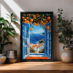 A vibrant framed canvas painting depicting an open Mediterranean-style window with blue shutters overlooking a coastal landscape. Above the window, ripe orange fruits hang from branches, framing a scenic view of white houses with terracotta roofs and a deep blue sea under a clear sky, rendered in a vivid, realistic style.