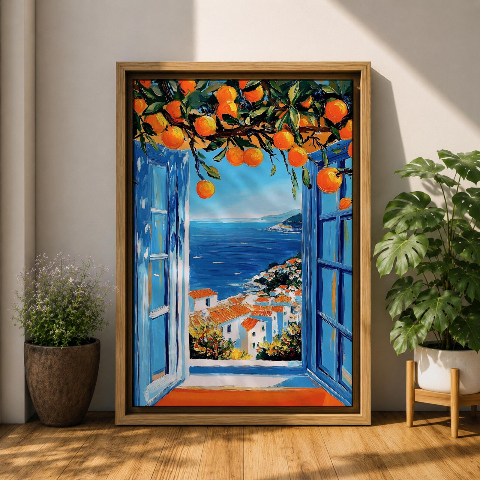 A vibrant framed canvas painting depicting an open Mediterranean-style window with blue shutters overlooking a coastal landscape. Above the window, ripe orange fruits hang from branches, framing a scenic view of white houses with terracotta roofs and a deep blue sea under a clear sky, rendered in a vivid, realistic style.
