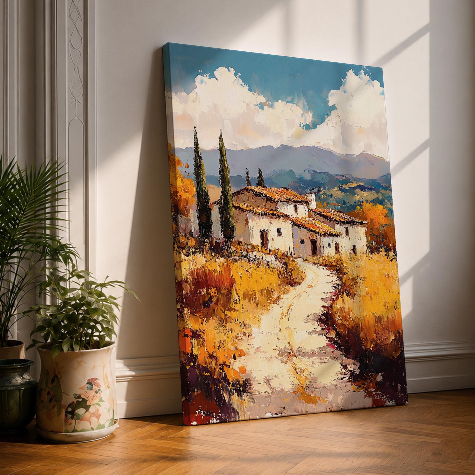 A vintage-style framed canvas painting depicting a Tuscan landscape with a winding path leading to rustic houses surrounded by tall cypress trees and golden fields under a partly cloudy sky, rendered in textured brushstrokes evoking a warm Italian countryside atmosphere.