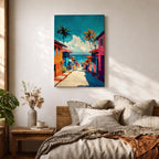 A vibrant painting depicting a tropical beach village with colorful houses lining a descending street toward the ocean. Palm trees rise above the rooftops under a bright blue sky with fluffy clouds. The artwork captures a lively coastal town atmosphere in a bold, illustrative style.