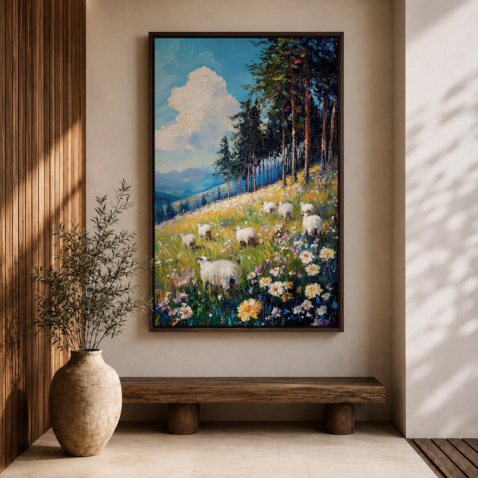This impasto style framed canvas depicts a scenic landscape of sheep grazing in a meadow filled with wildflowers, bordered by tall trees and distant mountains under a bright blue sky with fluffy clouds, rendered with thick textured brushstrokes that emphasize the natural rustic setting.