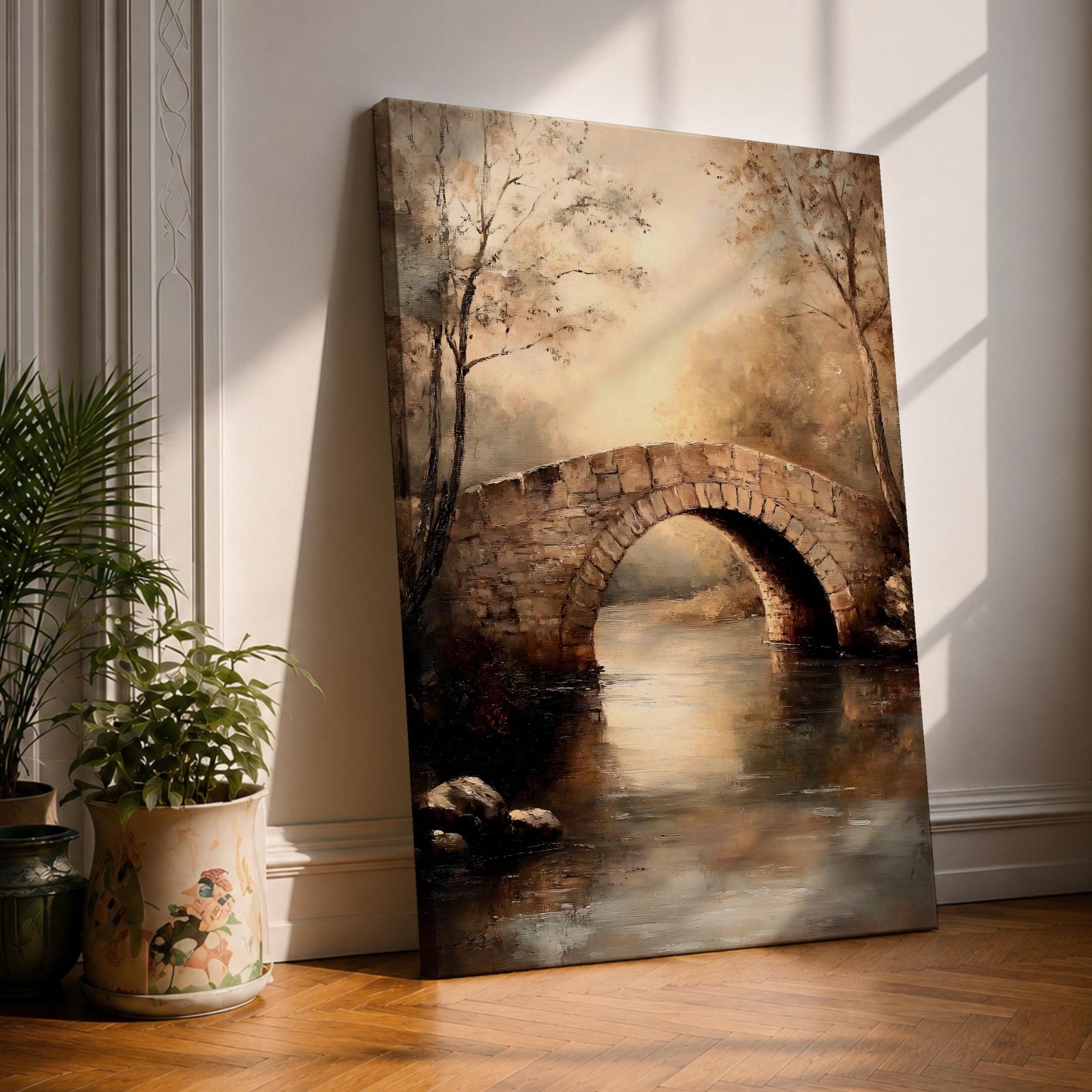 A vintage style framed canvas painting depicting a rustic stone arch bridge over calm water surrounded by trees and countryside landscape, rendered with soft brushstrokes and warm earthy tones, capturing a peaceful rural scene.