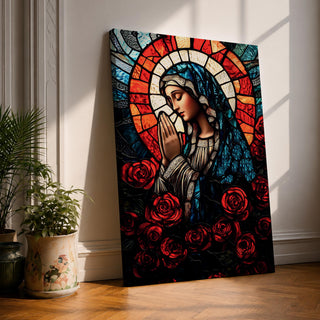 A stained glass style depiction of Virgin Mary with hands clasped in prayer, surrounded by red roses and a radiant halo behind her head. The image uses vibrant colors and intricate glass-like textures to create a mosaic effect emphasizing religious devotion and reverence.