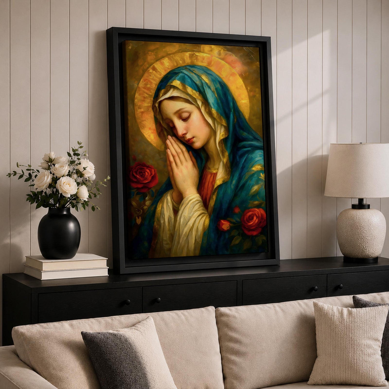 Portrait painting of the Blessed Virgin Mary shown with eyes gently closed and hands clasped in prayer, wearing a blue veil and cream garment while a radiant golden halo glows behind her head, with red roses appearing beside her in a devotional Madonna composition rendered in a soft classical style with warm painterly brushwork.