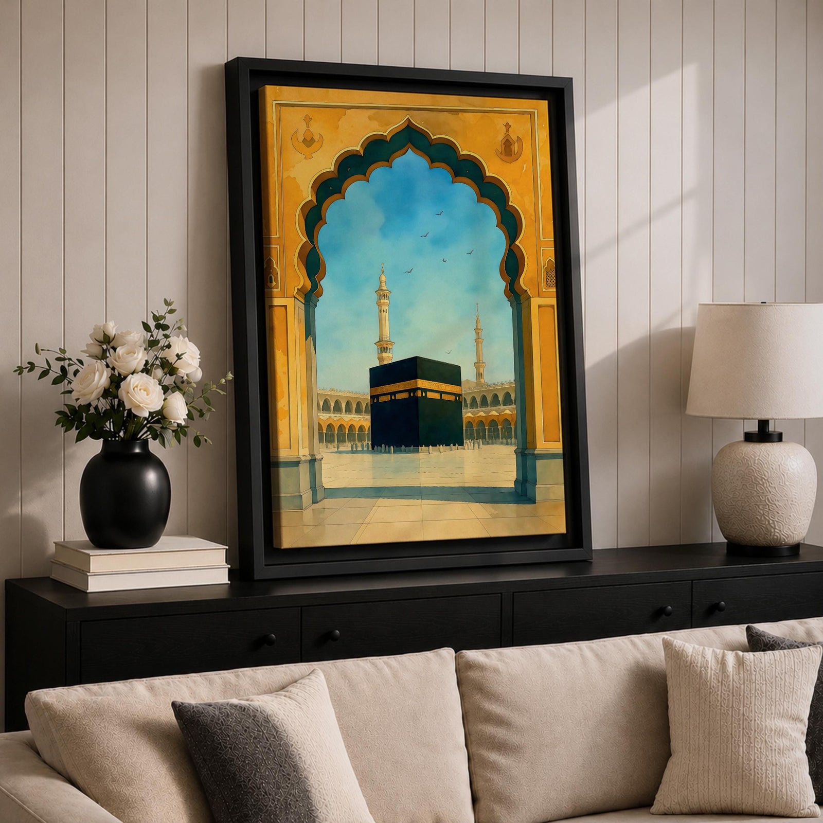 A watercolor style framed canvas wall art depicting the Kaaba viewed through an ornate Islamic arch with minarets and birds in the background. The artwork captures the iconic religious site in Mecca with detailed architectural elements and a serene sky, emphasizing Islamic cultural heritage.