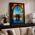 A vibrant framed canvas artwork depicting the Kaaba viewed through a golden arched doorway at Masjid Al Haram in Mecca. The scene shows the iconic black cube structure with gold detailing, two minarets in the background, and a reflective tiled floor under a bright blue sky with birds flying.